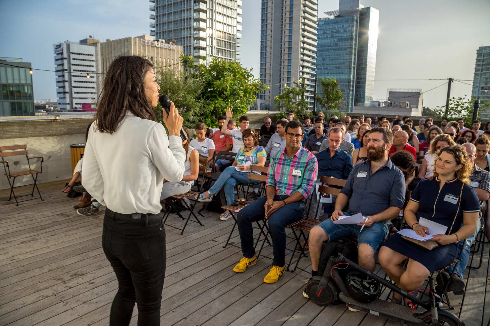Dana zelicha OWBA founder at a rooftop speaking event in front of a large audience